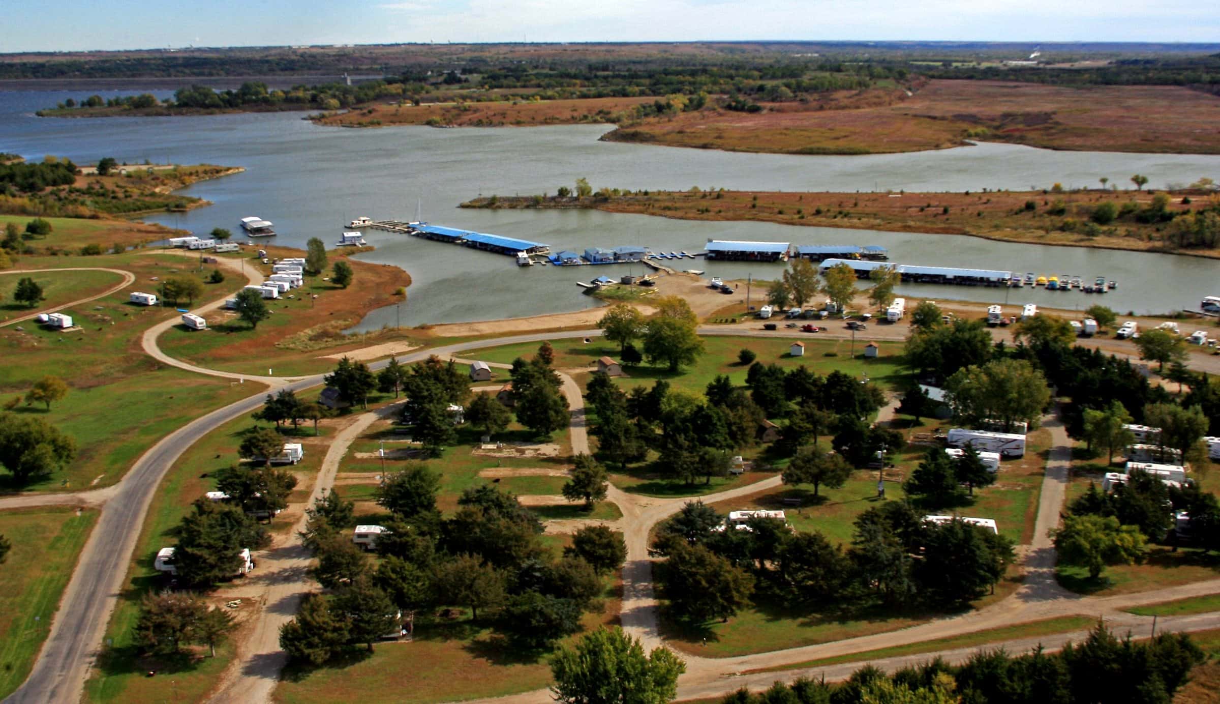 Aerial view of Thunderbird Marina & RV Resort: wooded campground loops, covered docks and Milford Lake