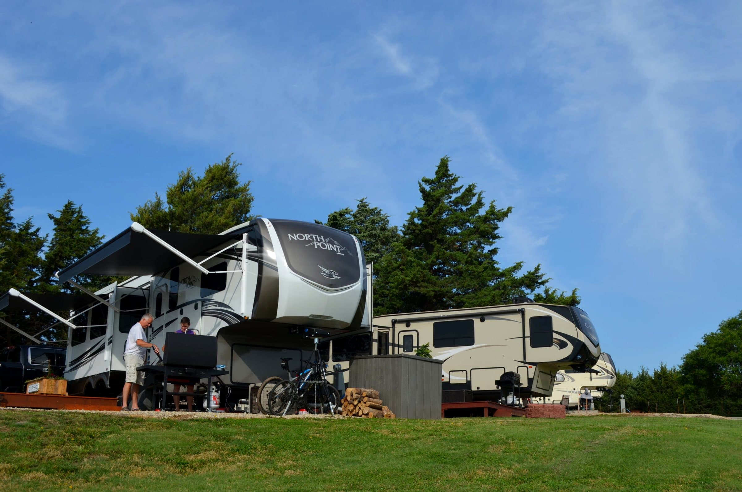 Fifth-wheel camper set up under the trees at Thunderbird