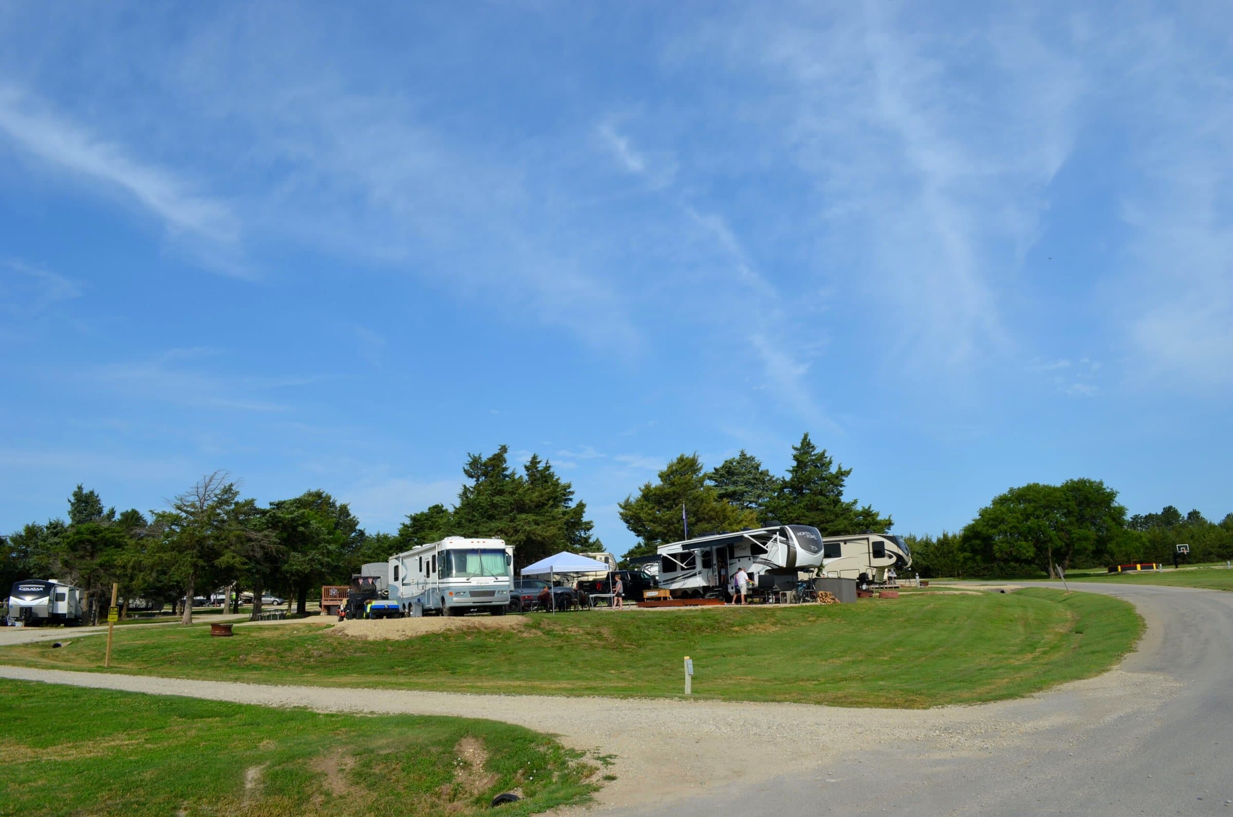 Campground road lined with RVs under a big sky